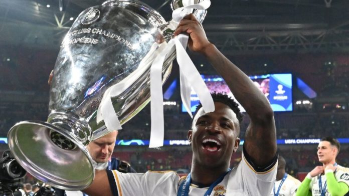 El delantero brasileño del Real Madrid Vinicius Junior posa con el trofeo de la Liga de Campeones de la UEFA.