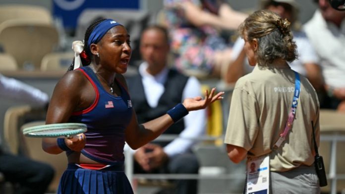 La estadounidense Coco Gauff habla con un árbitro después de que se sancionara una falta contra ella mientras jugaba contra la croata Donna Vekic.