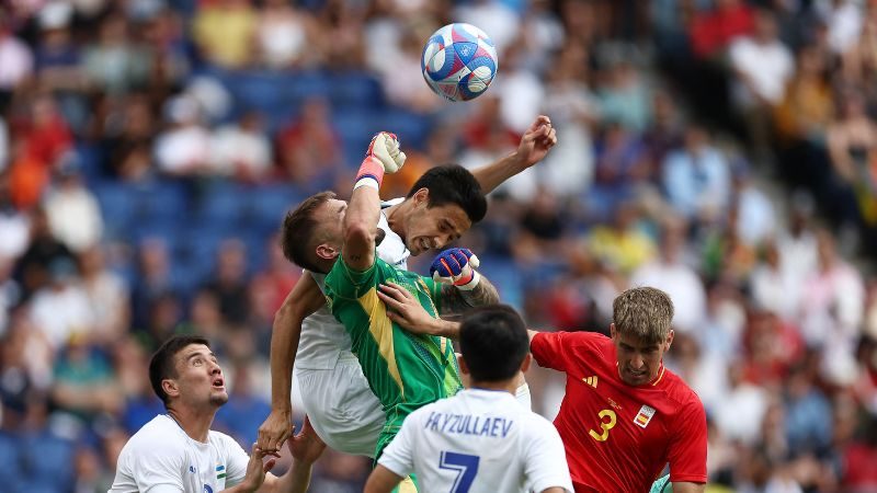 El portero de España, Arnau Tenas, lucha por el balón con el defensor de Uzbekistán, Khusniddin Alikulov.