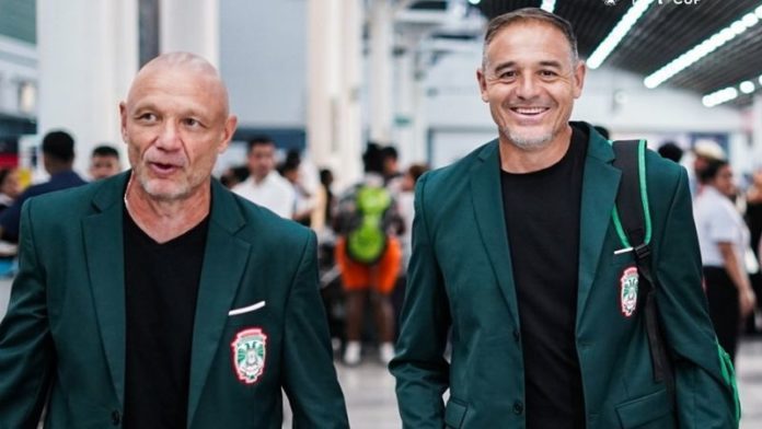 El preparador físico, Juan Bertani y el técnico, Hernán "La Tota" Medina, viajan bien elegantes hacia Costa Rica.