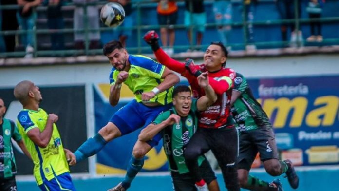 El portero de Juticalpa FC, Mariano Pineda, aleja el balón de puños, en una de las llegadas de los atacantes de Potros de Olancho FC.