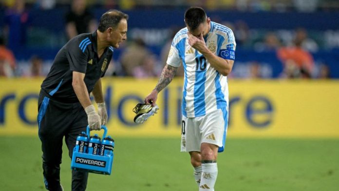 El delantero argentino Lionel Messi abandona el campo tras sufrir una lesión durante la final de la Copa América 2024.