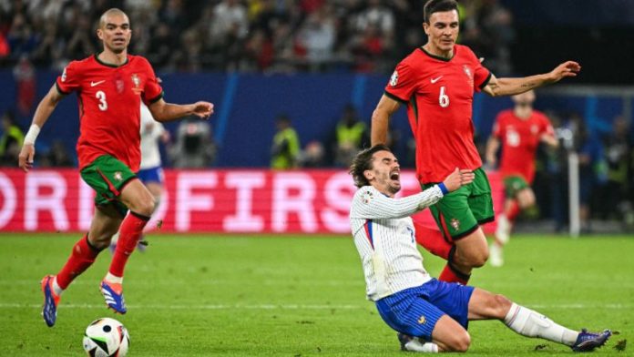 En la foto de archivo, el centrocampista francés Antoine Griezmann choca con el centrocampista portugués Joao Palhinha.