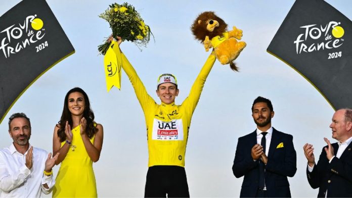 El ciclista esloveno, Tadej Pogacar, del equipo UAE Team Emirates, celebra su victoria general en el podio con el maillot amarillo de líder de la general después de la 21.ª y última etapa de la 111.ª edición del Tour de Francia.