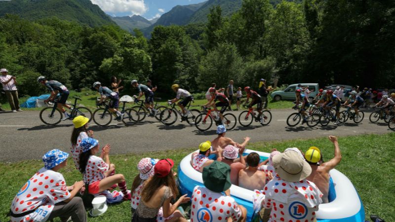 Los espectadores en una piscina inflable vitorean mientras el grupo de ciclistas (pelotón) pasa en bicicleta durante la 15a etapa de la 111a edición de la carrera ciclista del Tour de Francia.