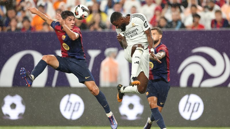 El defensa del Barcelona, ​​Alex Valle, compite por el balón con el zaguero alemán del Real Madrid, Antonio Rudiger.