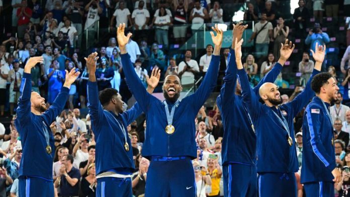 El medallista de oro estadounidense LeBron James y sus compañeros de equipo celebran en el podio.