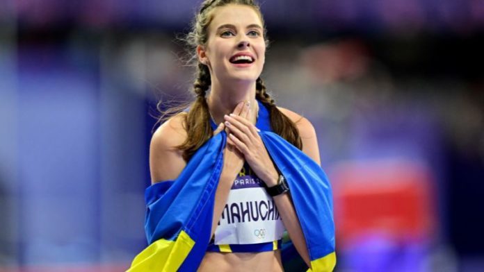 La medallista de oro ucraniana Yaroslava Mahuchikh celebra con la bandera de su país después de competir en la final de salto de altura femenino.