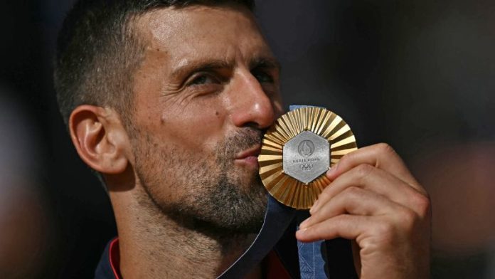 El medallista de oro, el serbio Novak Djokovic besa su presea en el podio en la ceremonia de presentación del evento de tenis individual masculino.