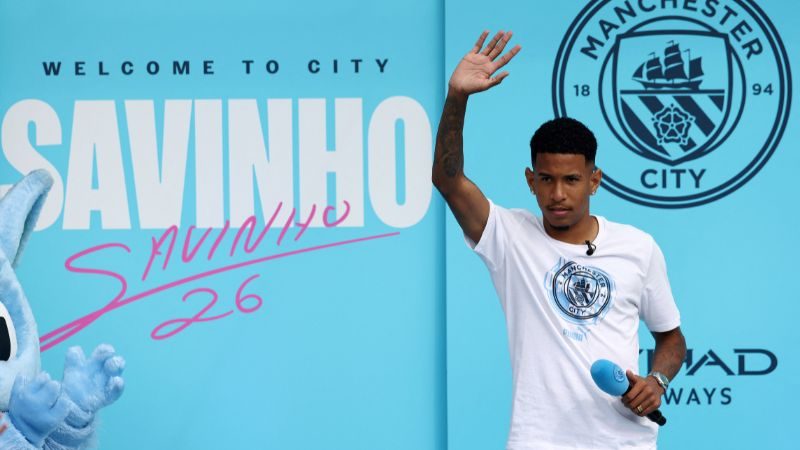 El nuevo delantero brasileño del Manchester City, Savinho, saludó durante una presentación oficial en el estadio Etihad de Manchester.