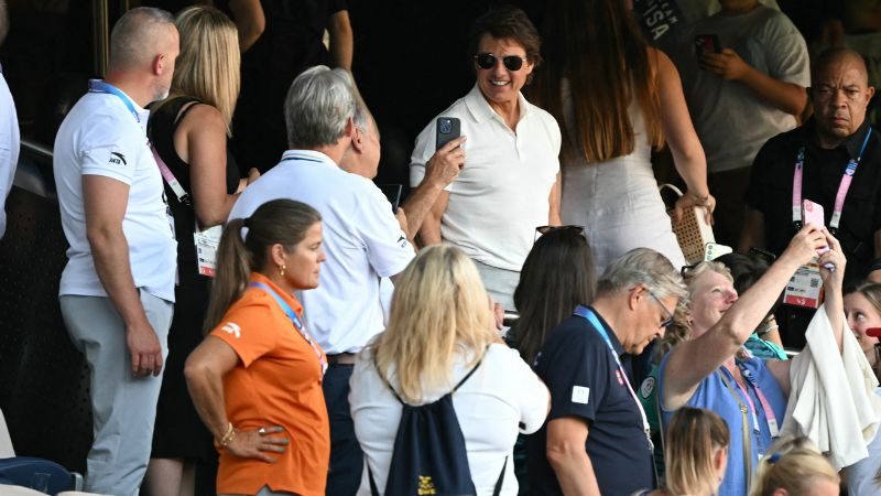 El actor estadounidense Tom Cruise sonríe mientras asiste al partido final de fútbol por la medalla de oro femenina entre Brasil y Estados Unidos.