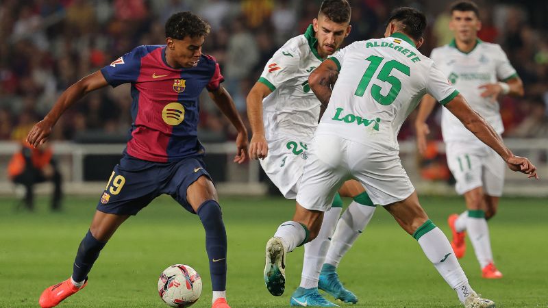 El delantero español del Barcelona, ​​Lamine Yamal, lucha por el balón con el defensa paraguayo del Getafe, Omar Alderete.