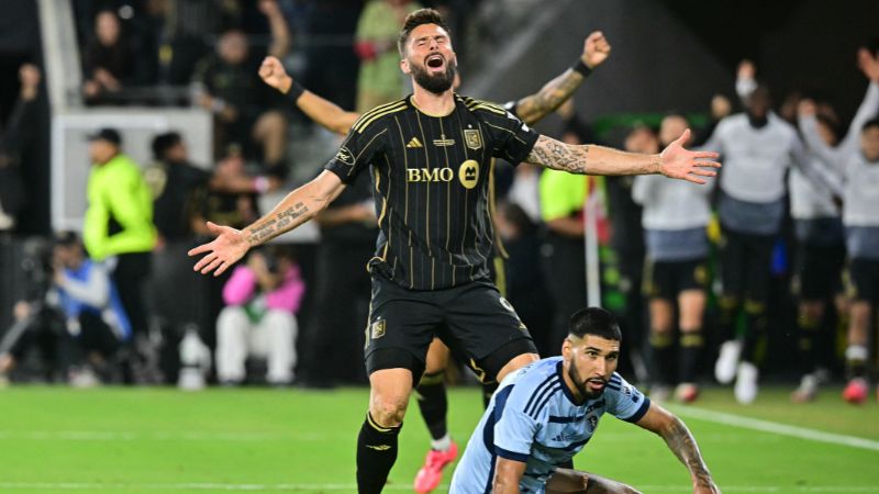 El delantero francés del LAFC, Olivier Giroud, celebra el primer gol de su equipo mientras el defensor estadounidense del Sporting KC, Robert Castellanos, observa.