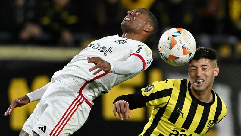 El centrocampista uruguayo de Flamengo, Nicolás de La Cruz y el defensa argentino de Peñarol, Damián García, luchan por el balón.