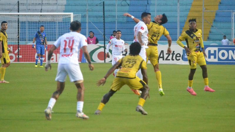 Roberto Moreira salta por el balón con Edwin Rodríguez, buscando habilitar a Marlon Ramírez.