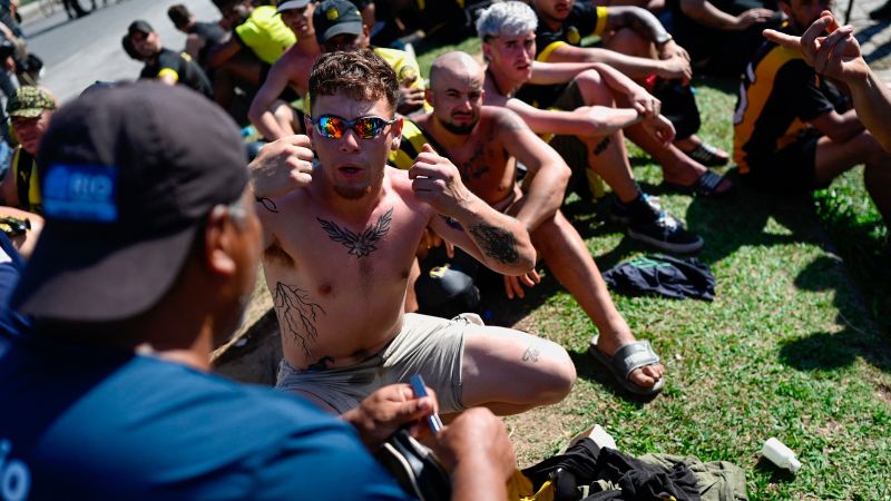 Un guardia municipal encuentra un cuchillo de barbero mientras registra las pertenencias de hinchas del Peñarol de Uruguay.