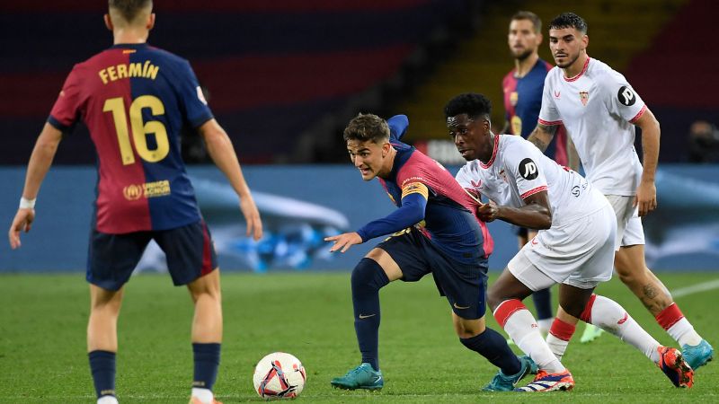 El centrocampista español del Barcelona, Pablo Gavi y el centrocampista belga del Sevilla, Albert-Mboyo Sambi Lokonga compiten por el balón.