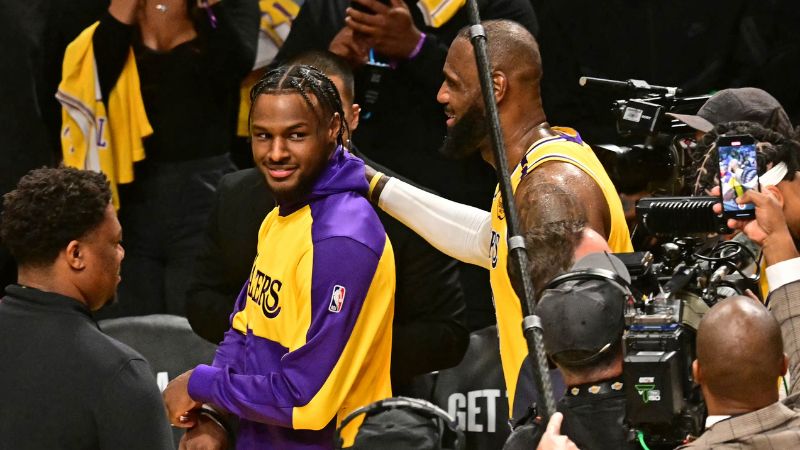 LeBron James y su hijo, el base de Los Angeles Lakers, Bronny James, salen de la cancha al final del partido inaugural de la temporada de la NBA contra el Minnesota Timberwolves.