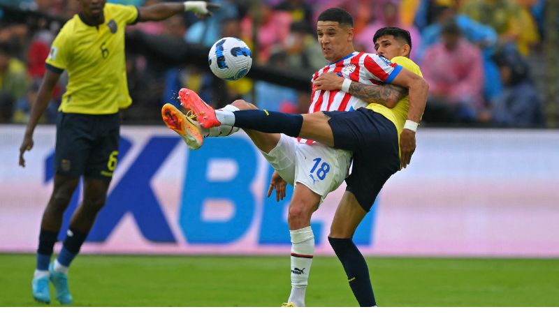 El delantero de Paraguay Alex Arce y el defensor de Ecuador Piero Hincapie luchan por el balón durante el partido eliminatorio.