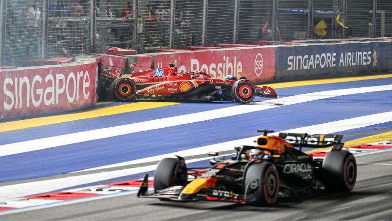 El piloto holandés de Red Bull Racing, Max Verstappen pasa mientras el piloto español de Ferrari, Carlos Sainz, se estrella durante la sesión de clasificación antes de la carrera nocturna del Gran Premio de Fórmula Uno de Singapur.