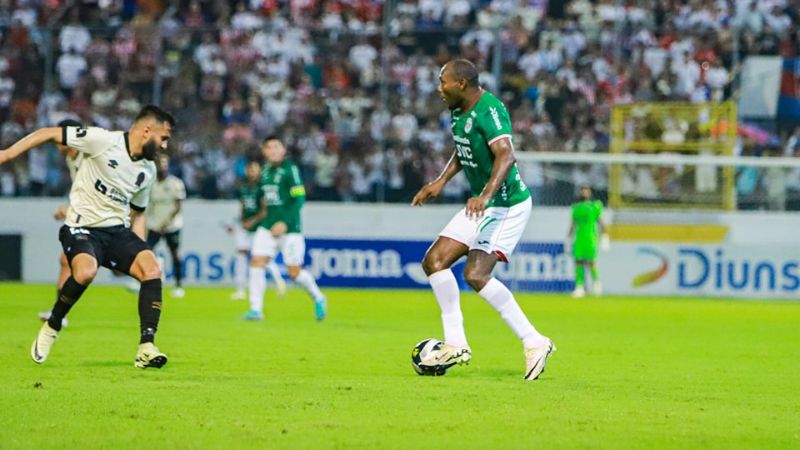 El delantero ecuatoriano de Marathón, Juan Anangonó enfrenta al olimpista, Jorge Álvarez.