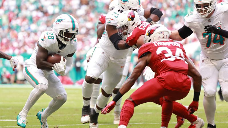 De'Von Achane, de los Miami Dolphins, corre con el balón mientras Jalen Thompson, de los Arizona Cardinals defiende.