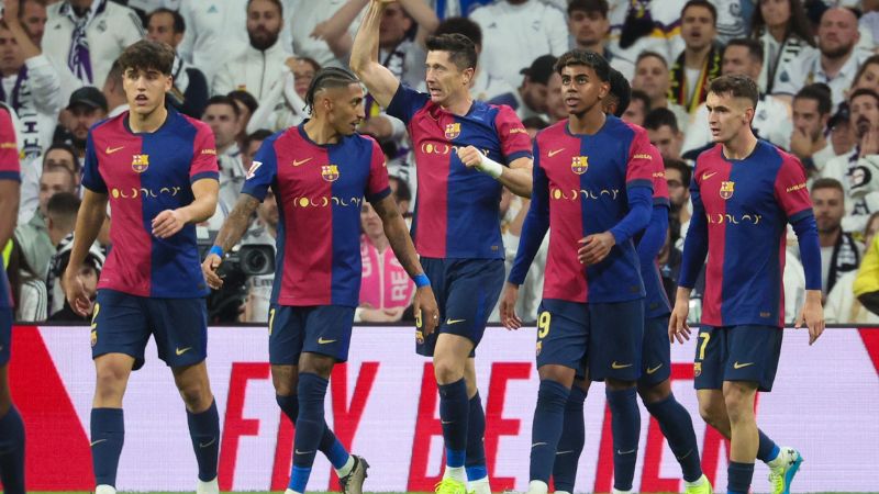 El delantero polaco del Barcelona, ​​Robert Lewandowski, celebra con sus compañeros de equipo después de marcar su primer gol frente al Real Madrid.