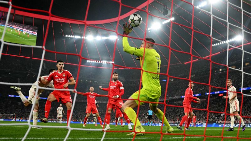 El portero ucraniano del Benfica, Anatolii Trubin, no logra detener el balón mientras el mediocampista alemán del Bayern Munich, Jamal Musiala, marca el gol del 1-0.