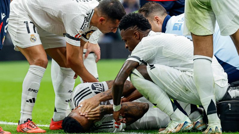 Compañeros de equipo revisan al defensor brasileño del Real Madrid, Eder Militao, luego de sufrir una lesión de rodilla.