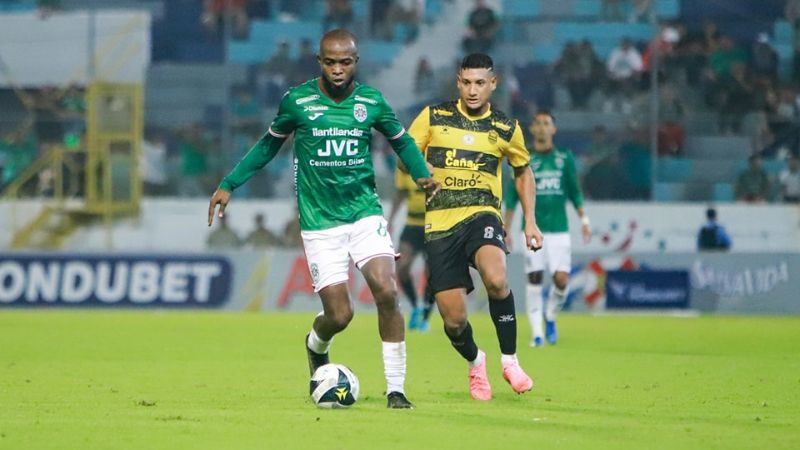 El volante de contención de Marathón, Gerson Chávez, controla el balón ante la mirada de Brayan Acosta, del Real España.