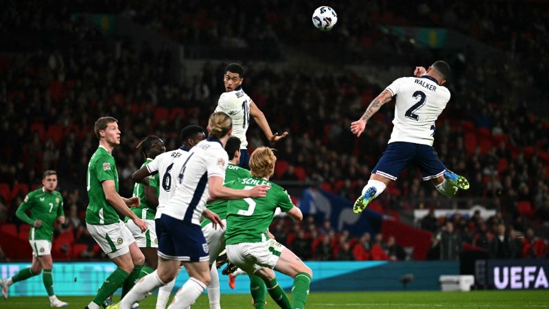  El defensa de Inglaterra, Kyle Walker y el mediocampista Jude Bellingham, saltan para cabecear el balón.