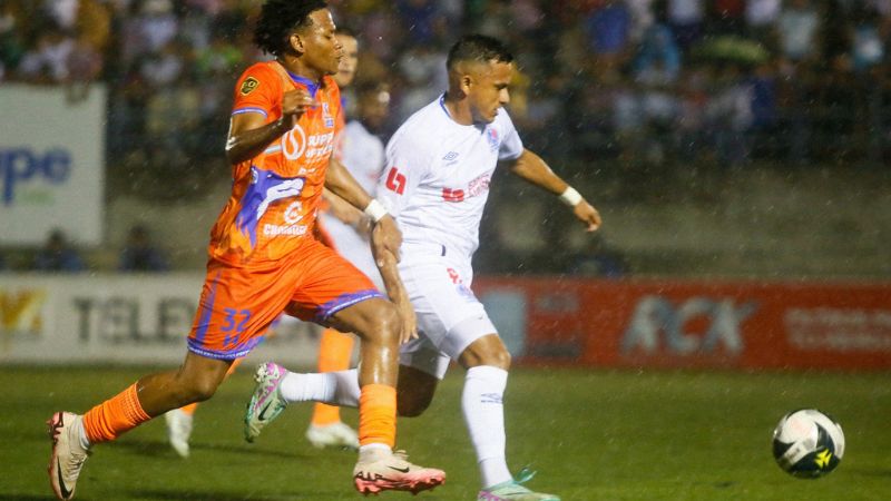 El mediocampista de Lobos UPNFM, Justin Ponce, disputa el balón con el olimpista, Edwin Rodríguez.