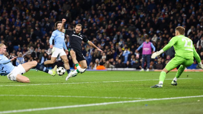 El delantero noruego del Manchester City, Erling Haaland, dispara y marca el tercer gol de su equipo ante el portero alemán del Feyenoord, Timon Wellenreuther.