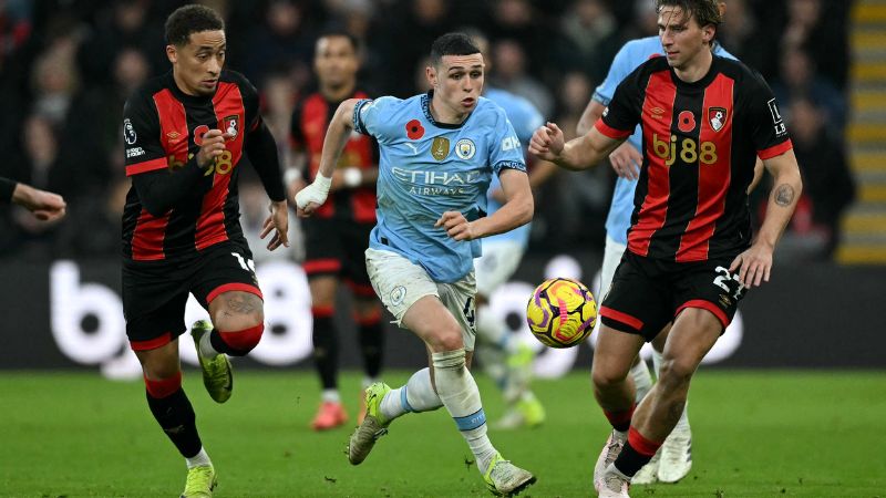 El centrocampista inglés del Manchester City, Phil Foden, corre con el balón presionado por el defensor ucraniano del Bournemouth, Illia Zabarnyi.