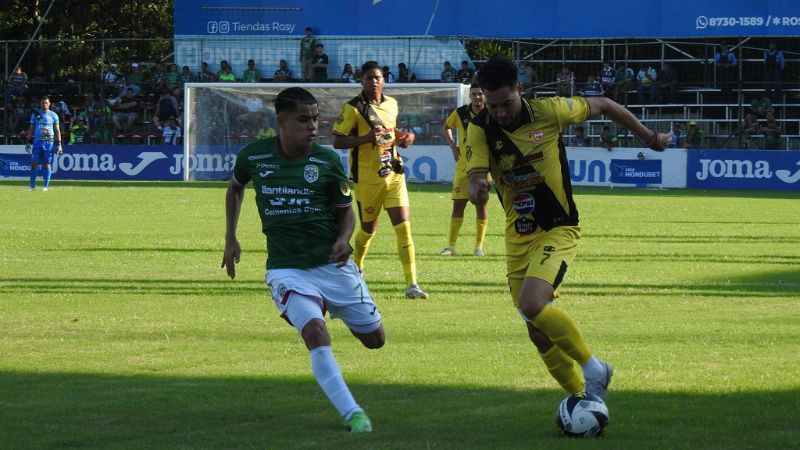 Marcelo Canales, de Génesis Comayagua, conduce el balón presionado por Isaac Castillo, de Marathón.