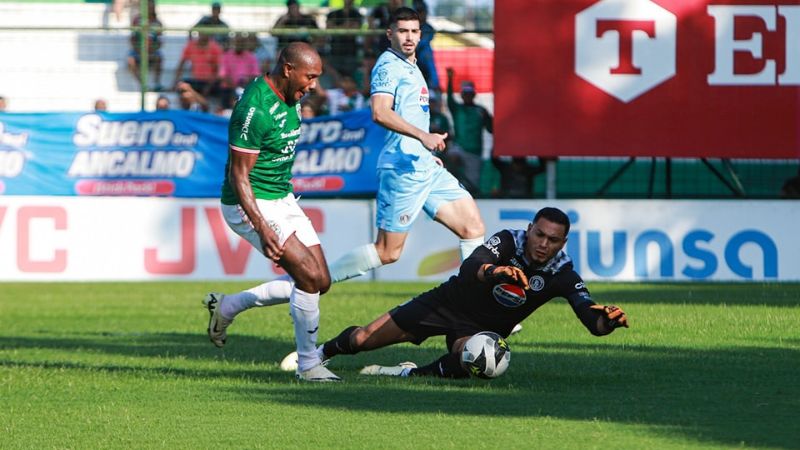 El portero de Motagua, Marlon Licona, sale de su marco para quedarse con el balón que buscaba Juan Anangonó.