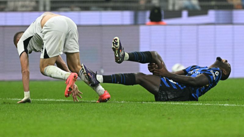 El defensa italiano del Nápoles, Alessandro Buongiorno, y el delantero francés del Inter de Milán, Marcus Thuram, caen al césped.