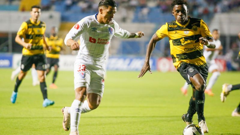 El delantero de Olimpia, Michaell Chirinos, conduce el balón ante la marca del Franklin Flores, del Real España.