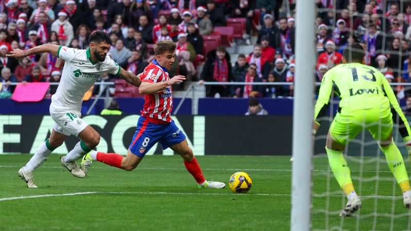 El centrocampista español del Atlético de Madrid, Pablo Barrios, intenta evadir al defensor paraguayo del Getafe, Omar Alderete.