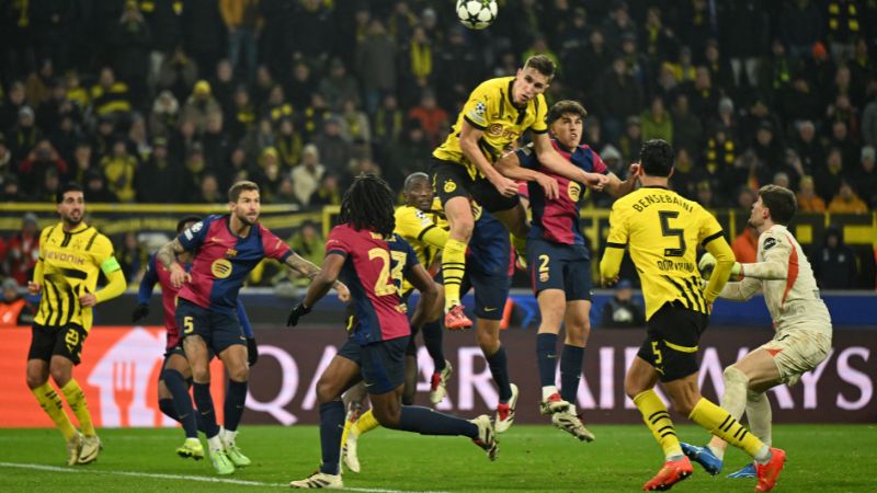 El defensa alemán del Borussia Dortmund, Nico Schlotterbeck, cabecea el balón durante el partido frente al Barcelona.