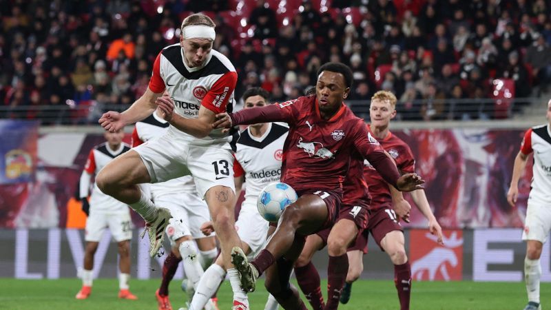 El delantero francés de Frankfurt, Hugo Ekitike, y el centrocampista austríaco de Leipzig, Nicolas Seiwald, compiten por el balón.