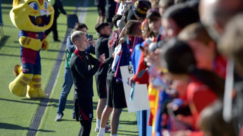 El delantero español del Barcelona, ​​Daniel Olmo, firma autógrafos durante una sesión de entrenamiento abierta a los aficionados en el campo Joan Gamper en Sant Joan Despí,