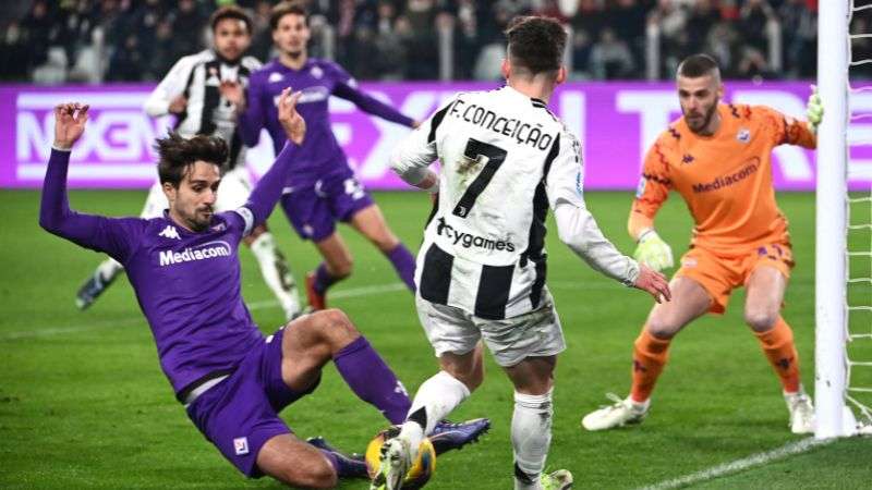 El delantero portugués de la Juventus, Francisco Conceicao, y el defensa italiano de la Fiorentina, Luca Ranieri, luchan por el balón.