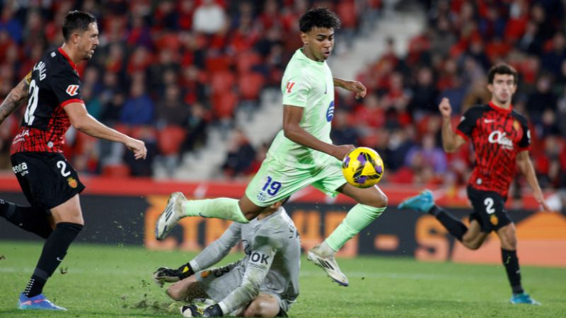 El delantero español del Barcelona, ​​Lamine Yamal, supera al portero español del Real Mallorca, Leo Román.