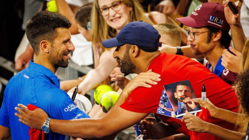 El serbio Novak Djokovic firma autógrafos después de su partido de dobles masculino con el australiano Nick Kyrgios.