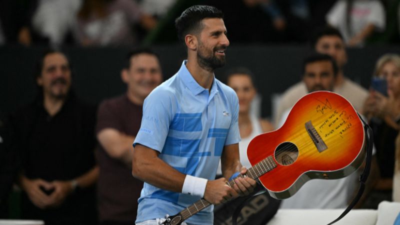 El serbio Novak Djokovic sostiene una guitarra que le regaló el cantante argentino Abel Pintos.