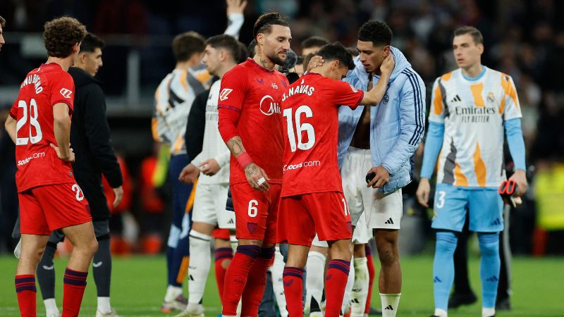 El centrocampista inglés del Real Madrid, Jude Bellingham, habla con el defensa español del Sevilla, Jesús Navas, al final del partido.