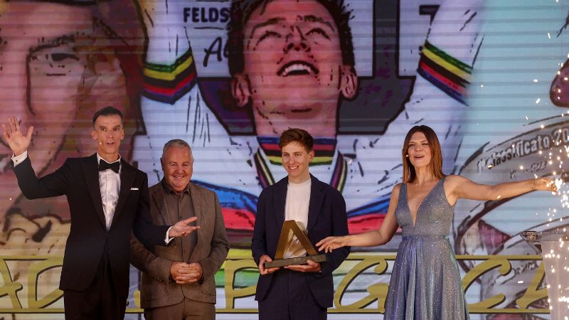 El ciclista esloveno, Tadej Pogacar, celebra tras recibir el trofeo masculino Velo d'Or junto al ex ciclista escocés David Millar y el ex ciclista irlandés Stephen Roche.