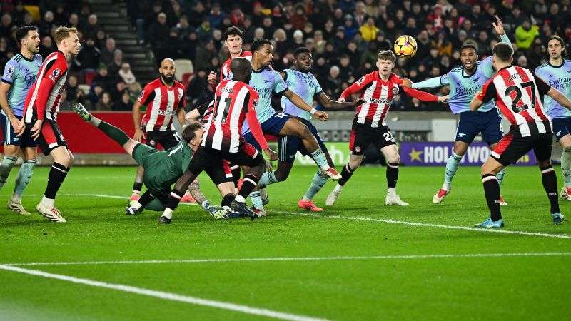 El portero holandés de Brentford, Mark Flekken, se lanza para salvar el balón mientras los jugadores de ambos equipos luchan por él.