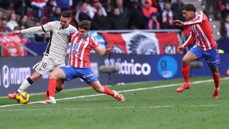 El centrocampista español de Osasuna, Moi Gómez, lucha por el balón con el delantero argentino del Atlético de Madrid, Julián Álvarez.